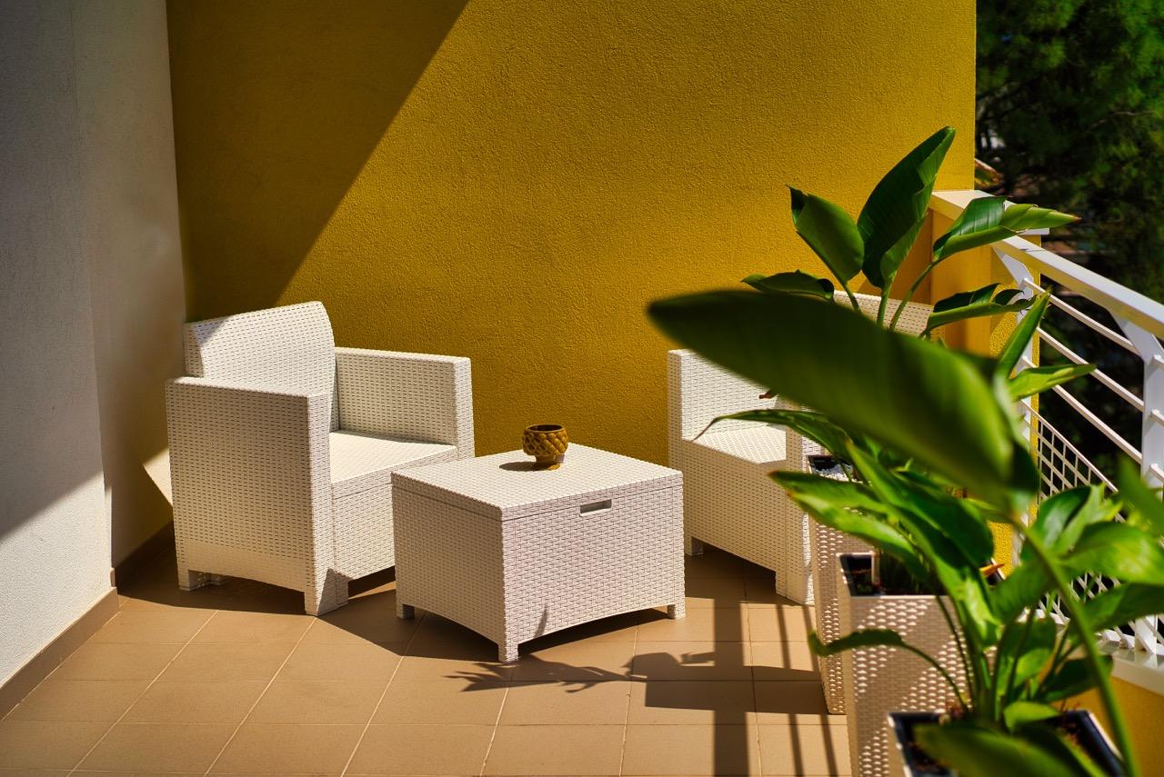 Balcone con poltrone e piante sotto il sole