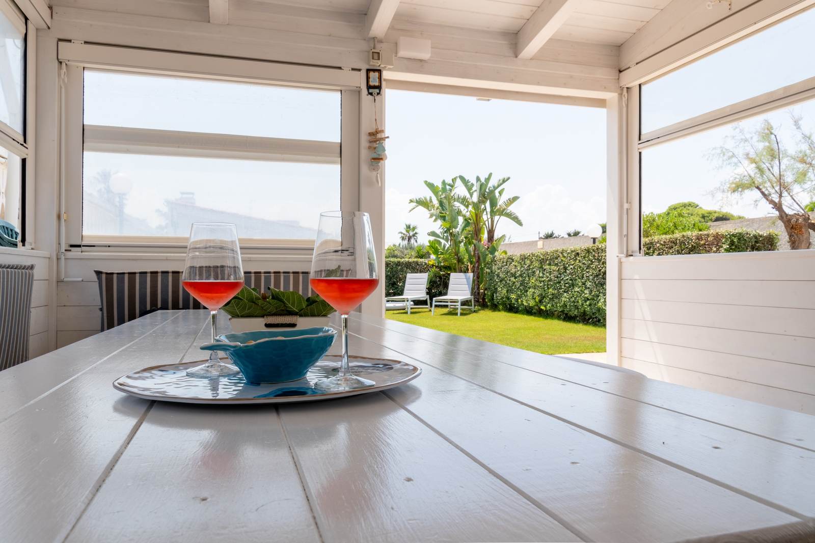 Veranda del Beach & Garden aperta sul giardino, con due calici di spritz